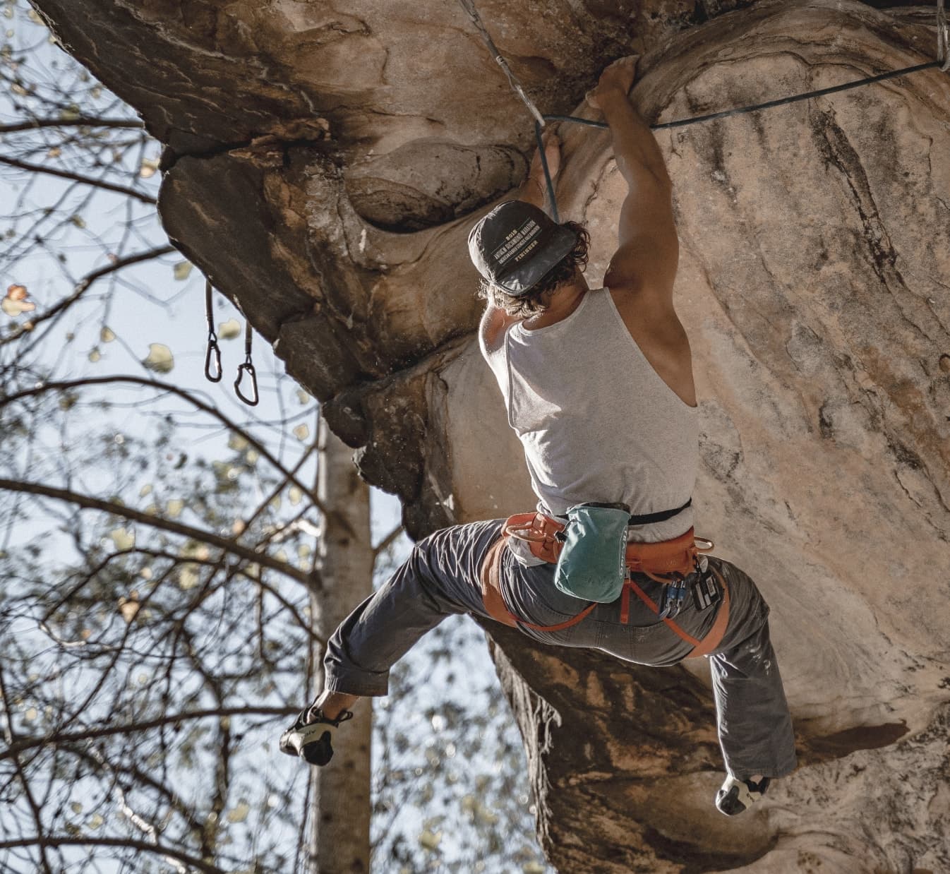 A guy climbing a steep mountain