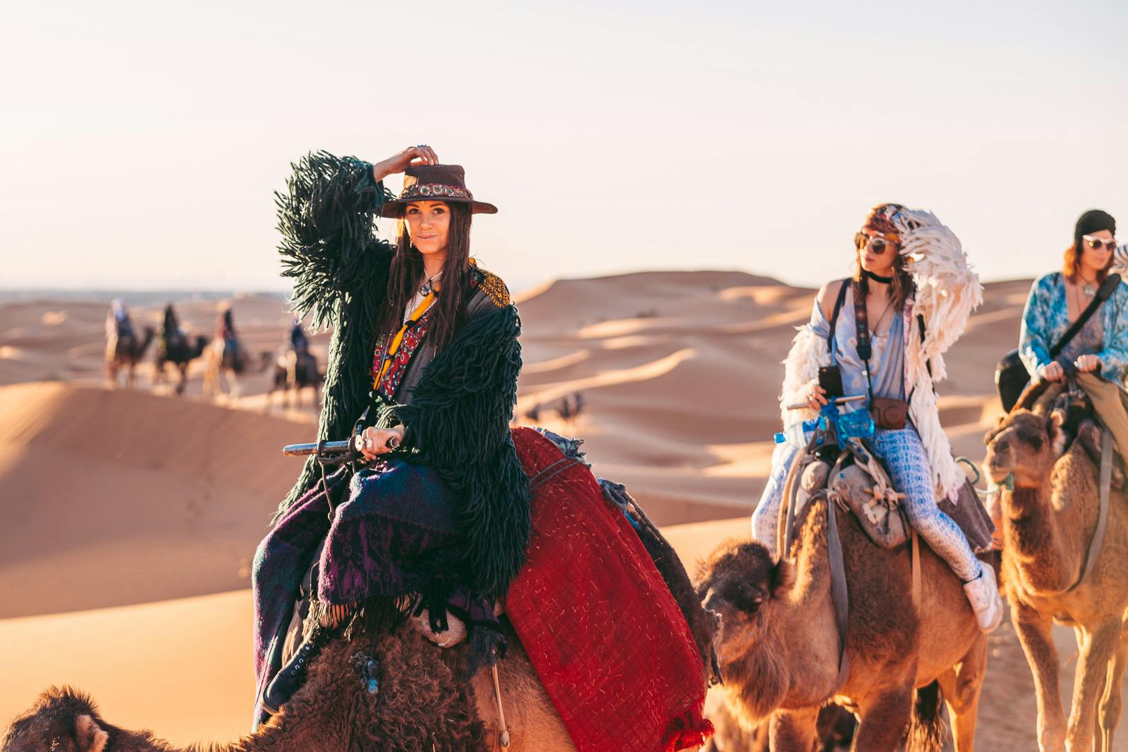 Women riding camels in the desert