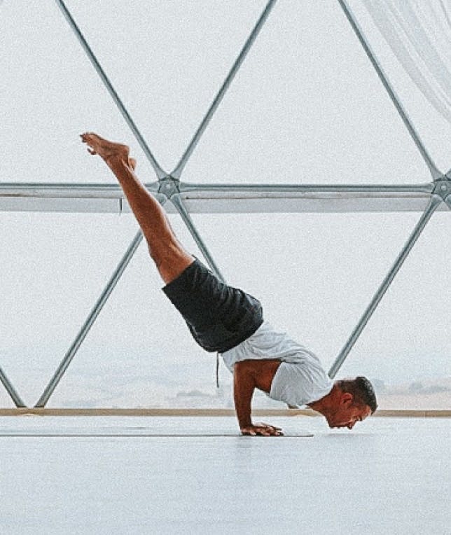 a yoga teacher handstanding