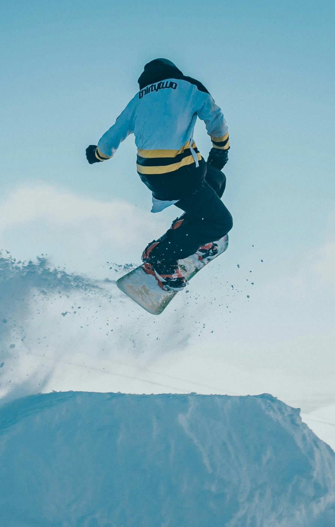 a snowboarder doing a trick photographed mid air